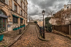 Rue Montmartre, le charme parisien à l'état pur. Cette rue historique de Paris, pavée de pierres, est bordée de cafés pittoresques et de boutiques élégantes